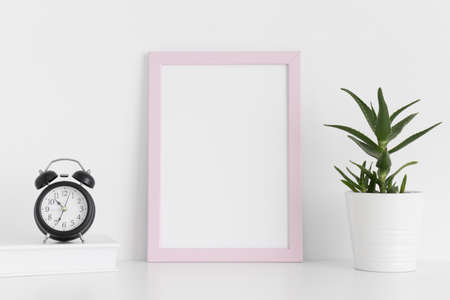Pink frame mockup with workspace accessories and a aloe vera on a white table.Portrait orientation.の写真素材