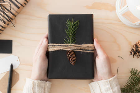 Woman holding a black christmas gift.の写真素材