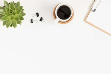 Workspace accessories, coffee and a succulent plant on a white table.  Flat lay with blank copy space.の写真素材