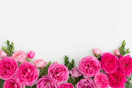 Pink roses on a white table. Flat lay with blank copy space.の写真素材