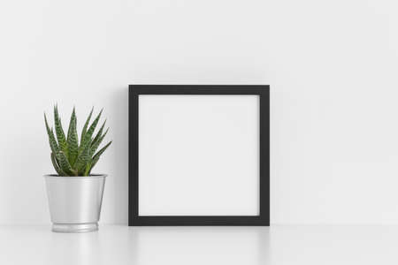 Black square frame mockup with a cactus in a pot on a white table.の写真素材