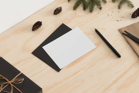 White card mockup with christmas decoration on a wooden table.の写真素材