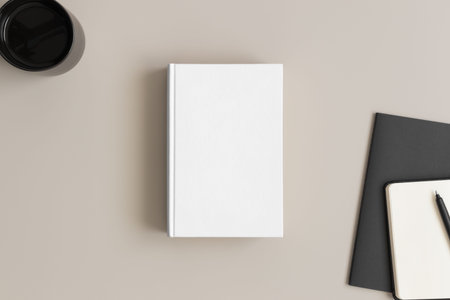 White book mockup with a cup of coffee and workspace accessories on a beige table.