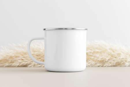 Enamel mug mockup with a pampas on a beige table.の写真素材