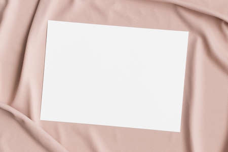 Invitation white card mockup on a beige textile. 5x7 ratio, similar to A6, A5.の写真素材