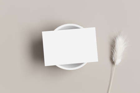 White business card mockup with a dried lagurus decoration on a beige table.の写真素材
