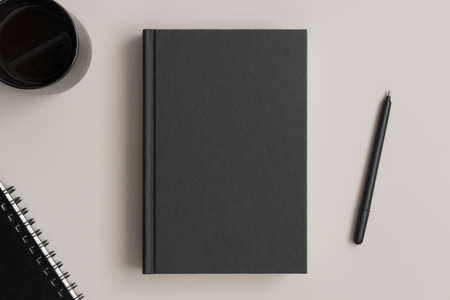 Black book mockup with workspace accessories on a beige table.の写真素材