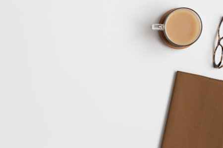 Workspace accessories  and a cup of a coffee on a white table.  Flat lay with blank copy space.の写真素材