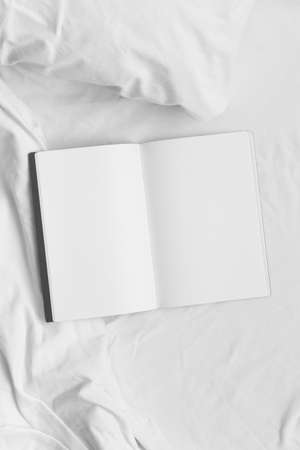 Open notebook mockup on the bed.の写真素材