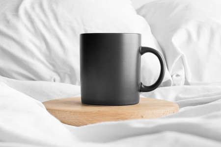 Black mug mockup on the bed.の写真素材