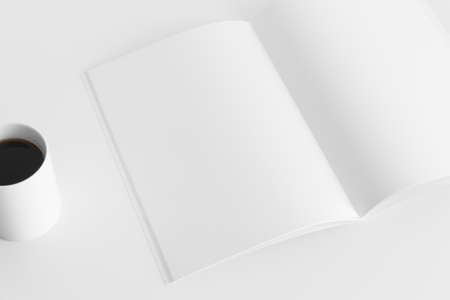 Open magazine mockup with a cup of coffee  on the white table.の写真素材