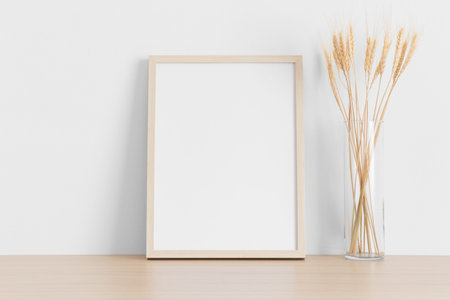 Wooden frame mockup with dried flowers on the wooden table.