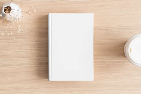 White book mockup with a gypsophila and a cup of coffee on the wooden table.の写真素材