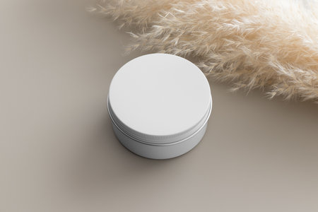 White cosmetic cream jar mockup with a pampas on the beige table.の写真素材