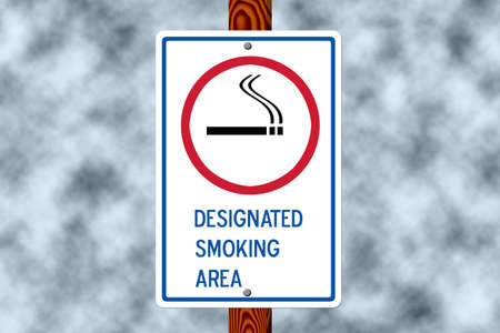 Designated smoking sign on a post against a dark smoke filled skyの写真素材
