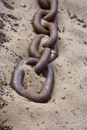old rusty chain close up laying on the beachの写真素材