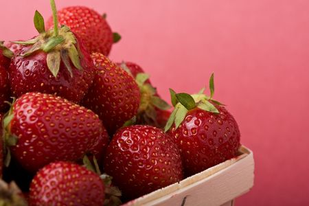 wooden quart of ripe strawberries on a solid backgroundの写真素材
