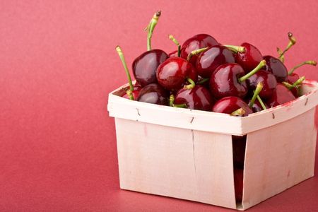 quart of ripe cherries in a wood containerの写真素材