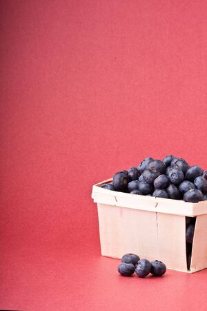 wooden quart of blueberries on a red backgroundの写真素材