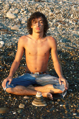 young man meditates on seacoastの写真素材