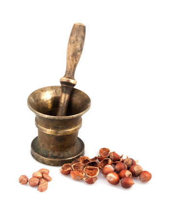 Brass mortar with pestle and nuts on white backgroundの写真素材