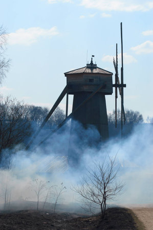 Windmill in smoke in  spring day