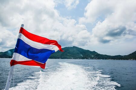 flag of Thailand on a ship in the sea, flag on a ferry with clear sky and deep blue sea backgroundの写真素材
