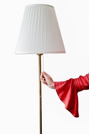Woman hand in red shirt switch on lamp.の写真素材