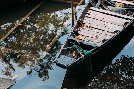 Wooden boat by the lake shore ,beautiful autumn time, calm water. Old paddle boat in autumnal scenery.の写真素材