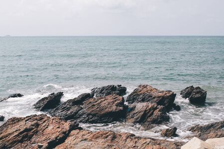 Waves crashing on the  rocks at the coast of Khao Laem Ya Mu Ko Samet National Park Rayong, Thailand in sunset timeの写真素材
