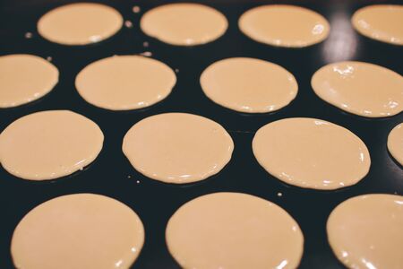a stall vendor pouring creamy batter on a hot plate to make Dorayaki, a Japanese pancake-like dessert & a street snack popularの写真素材