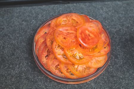 Fresh tomatoes in a glass bowl Healthy vegetable vitamins  view from directly above. for cooking cut tomatoes in a bowl, prepared for cooking bbq, raw ingredientの写真素材