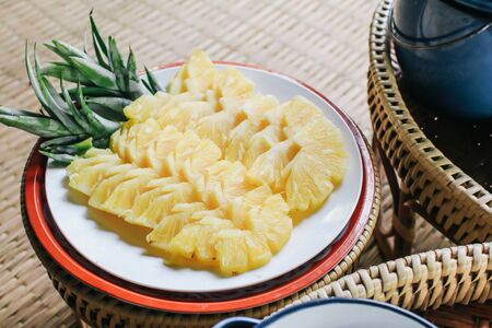 slices of pineapple on bamboo basket and burlap served on table top tropical fruitの写真素材