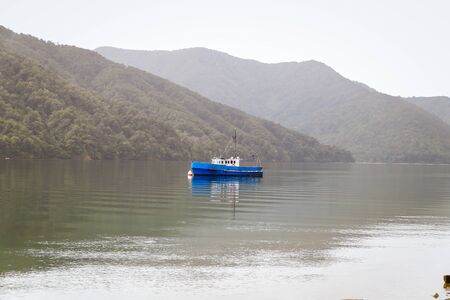 calm lake with reflection in the water. Serene scene landscape. Horizontal photograph. fishing boat in a calm lake water/old wooden fishing boat/ wooden fishing boat in a still lake waterの写真素材
