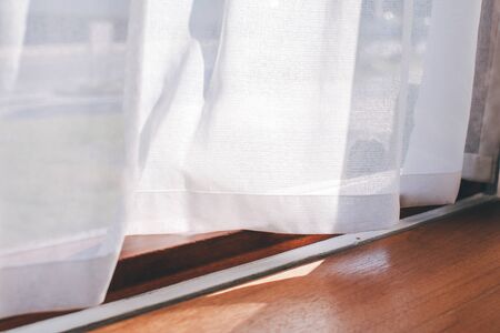 white curtains in living room Empty white room with curtains on windows, white room interior with waving curtain by fresh air, White curtain blown by windの写真素材