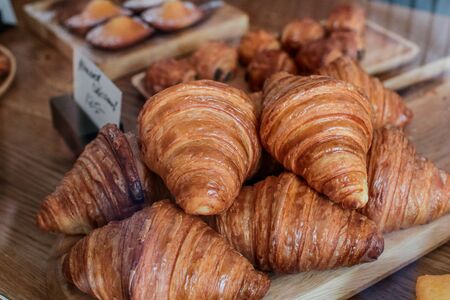 freshly baked croissants on wooden cutting board Warm Fresh Buttery Croissants and Rolls. French and American Croissants and Baked Pastriesの写真素材