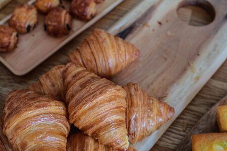 freshly baked croissants on wooden cutting board Warm Fresh Buttery Croissants and Rolls. French and American Croissants and Baked Pastriesの写真素材