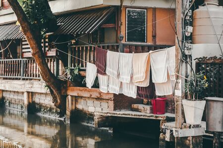 Close-up of multi-colored towels dried on a rope Washing line with white and fuchsia towels hanging to dry outside a rural houseの写真素材