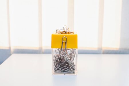 A lot of silver paper clip to white background.Magnetic box for put paper clips office supplies , business accessories.の写真素材