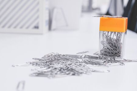 A lot of silver paper clip to white background.Magnetic box for put paper clips office supplies , business accessories.の写真素材