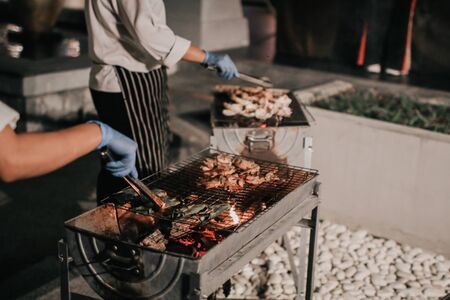 Grilled fresh seafood.Chef cook the bbq seafood on beach for dinner part, roasted seafood party, grilled lobster cook on charcoal stove. Grilled king prawns, squid on bbq fire.の写真素材