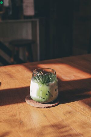 Iced matcha green tea latte with milk  on wooden table, Perfect for breakfast time..Japanese style. Design Copy Spaceの写真素材