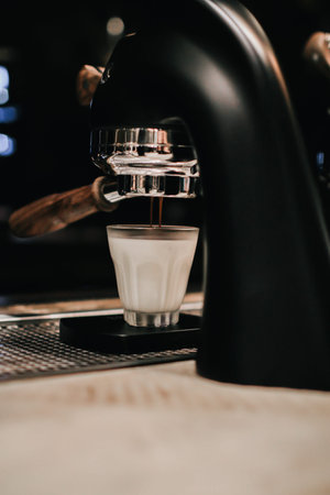 Close-up of Coffee made in professional espresso machine pouring into a cup.A strong looking fresh...