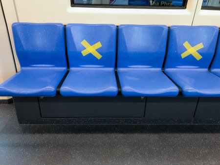 BANGKOK/THAILAND-Mar 29, 2020: Measure against COVID-19.Social distancing inside a MRT subway train. Yellow cross symbol on a seat means one shall not sit there.Infection control.のeditorial素材