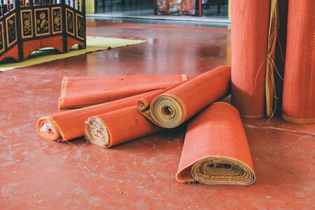 Thai style Red mat Buddhist use to sit for making merit by offering food to monks or do the ceremonial pouring water dedicating the merit to the anyone passed away in the temple floor.の写真素材
