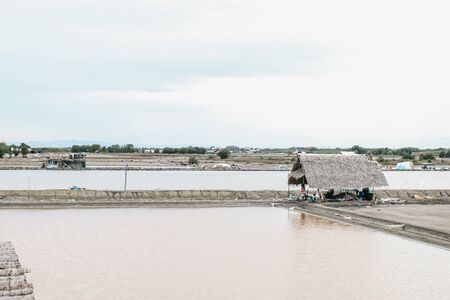 A barn that people build in Salt Farm, one of the few sun-dried salt-producing areas in Thailand.Beautiful landscape at sunset salt Farm. Salt Farm is the place with so much sea-salt production.の写真素材