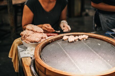 Asian Culture Street food booth selling Chinese specialty Steamed Dumplings preparation cooking in a bamboo basketの写真素材