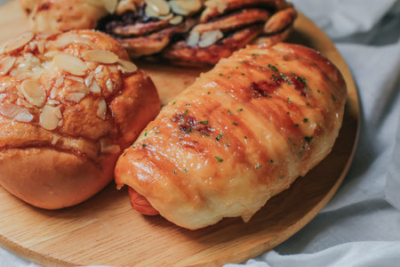 Breakfast fresh hot crusty bread rolls.Homemade sausages in dough with sesame and croissant with almonds on food market display white backgroundの写真素材