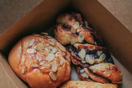 Pastries and bakery.Breakfast basket with tasty variety of homemade delicious breads and buns in brown box such as almond chocolate and sausage.の写真素材