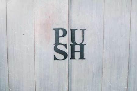 "Push" sign on wooden at entrance door handle restaurant vintage style .の写真素材